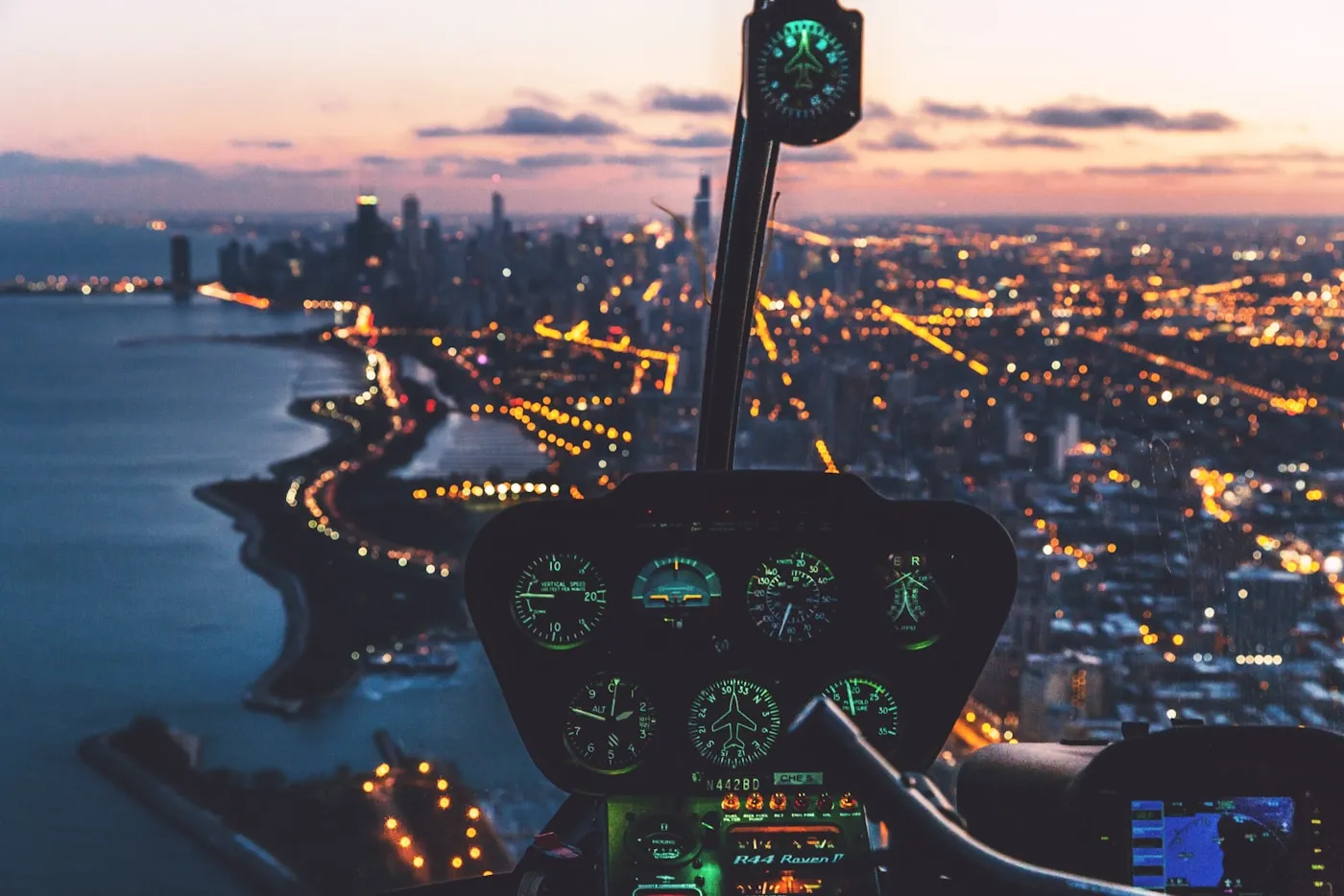 View of a city at dusk from inside a helicopter cockpit