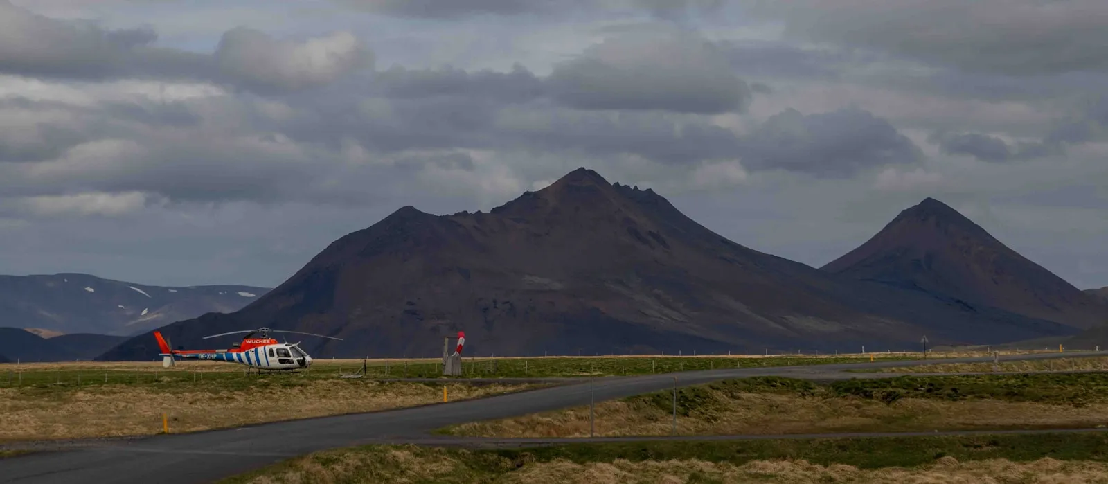 Helicopter positioned near a remote mountain landscape