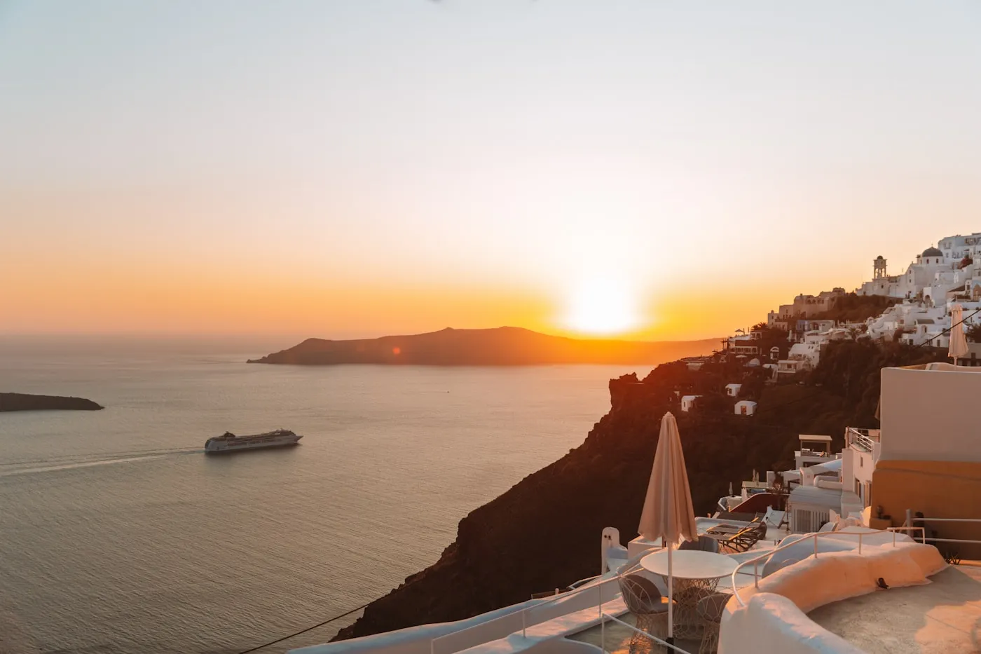 Cruise ship passing Santorini at sunset