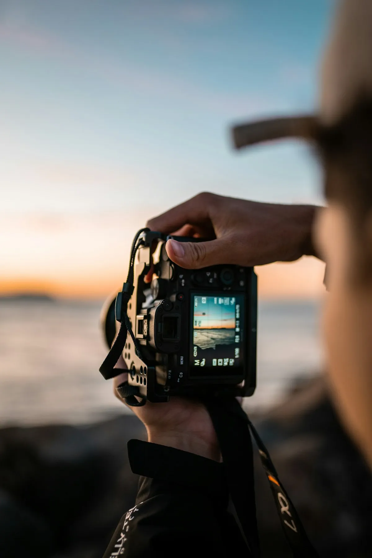 Photographer composing a coastal image with a professional camera